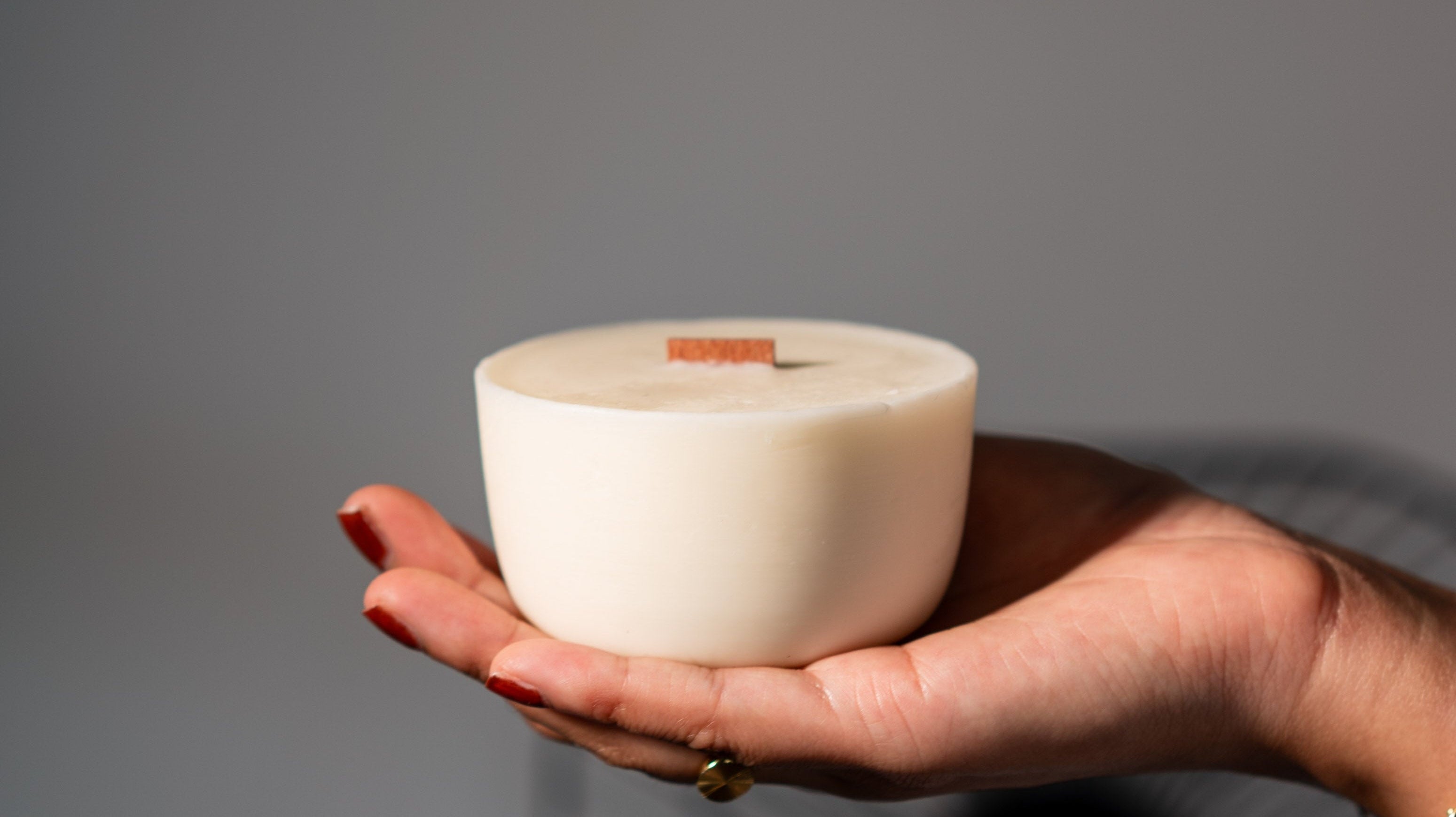 Hand holding a soy candle refill