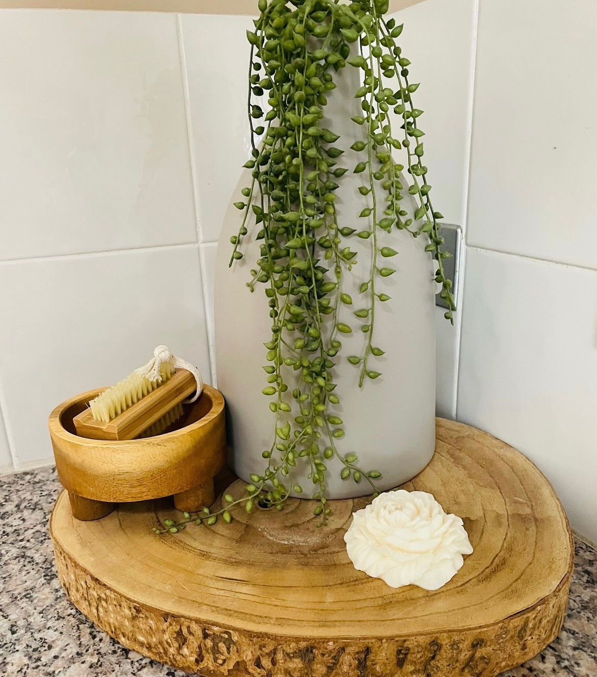 vegan products lunaire candle and body scrub on a wooden plate with greenery