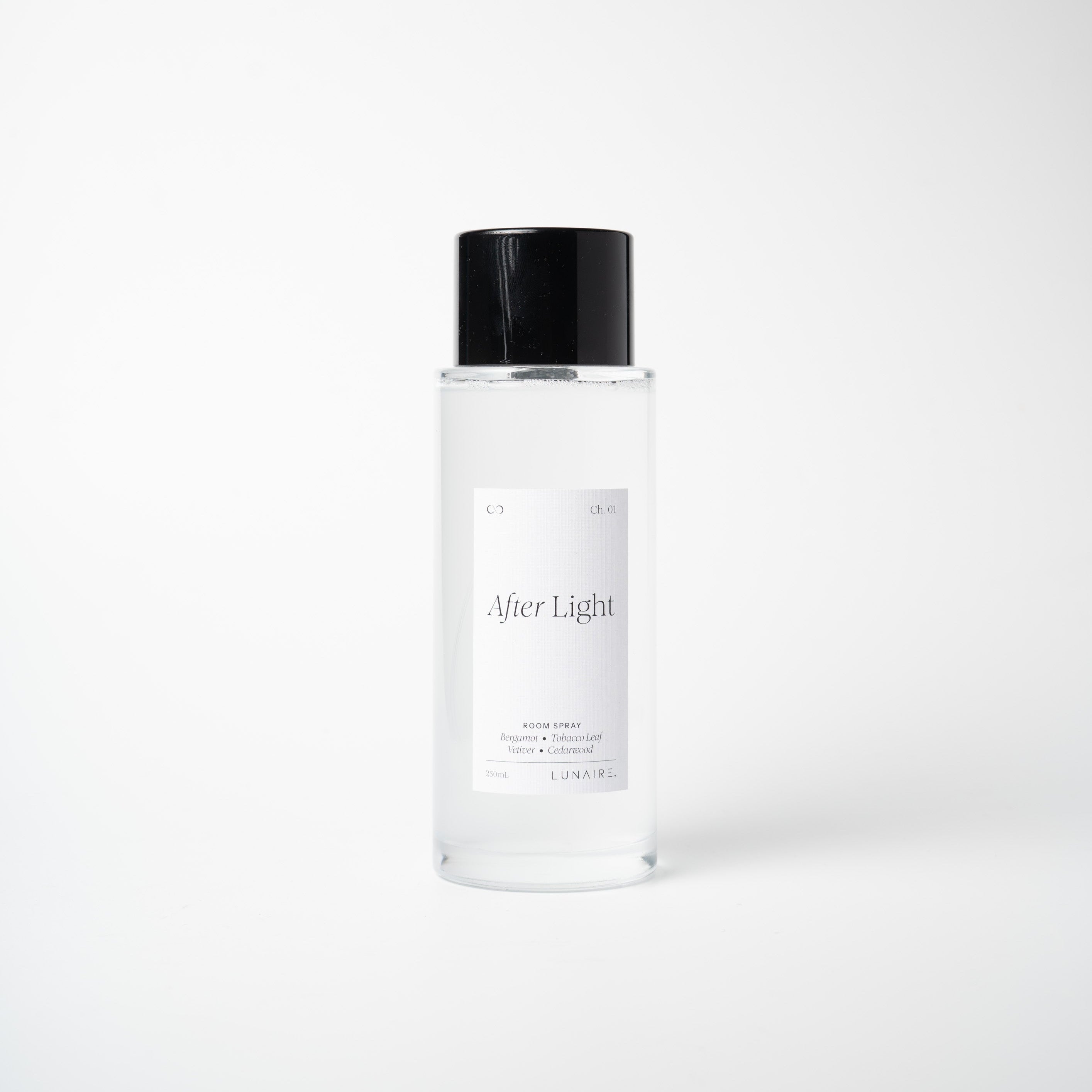 A clear glass bottle of After Light setting spray with a black cap and a minimalist white label, centered against a clean white background.