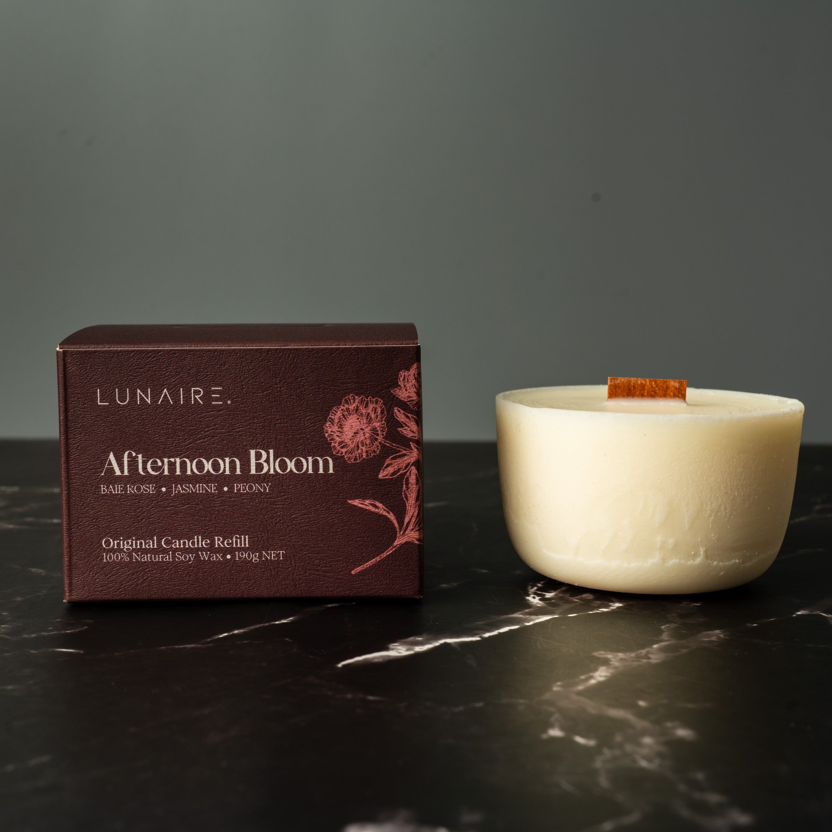 Lunaire Afternoon Bloom candle and packaging on a dark surface. Refillable Soy Candle Insert