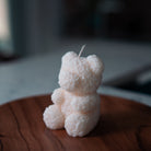 Bear Shaped Decorative Candle with intricate rose pattern placed on top of a round wooded surface.