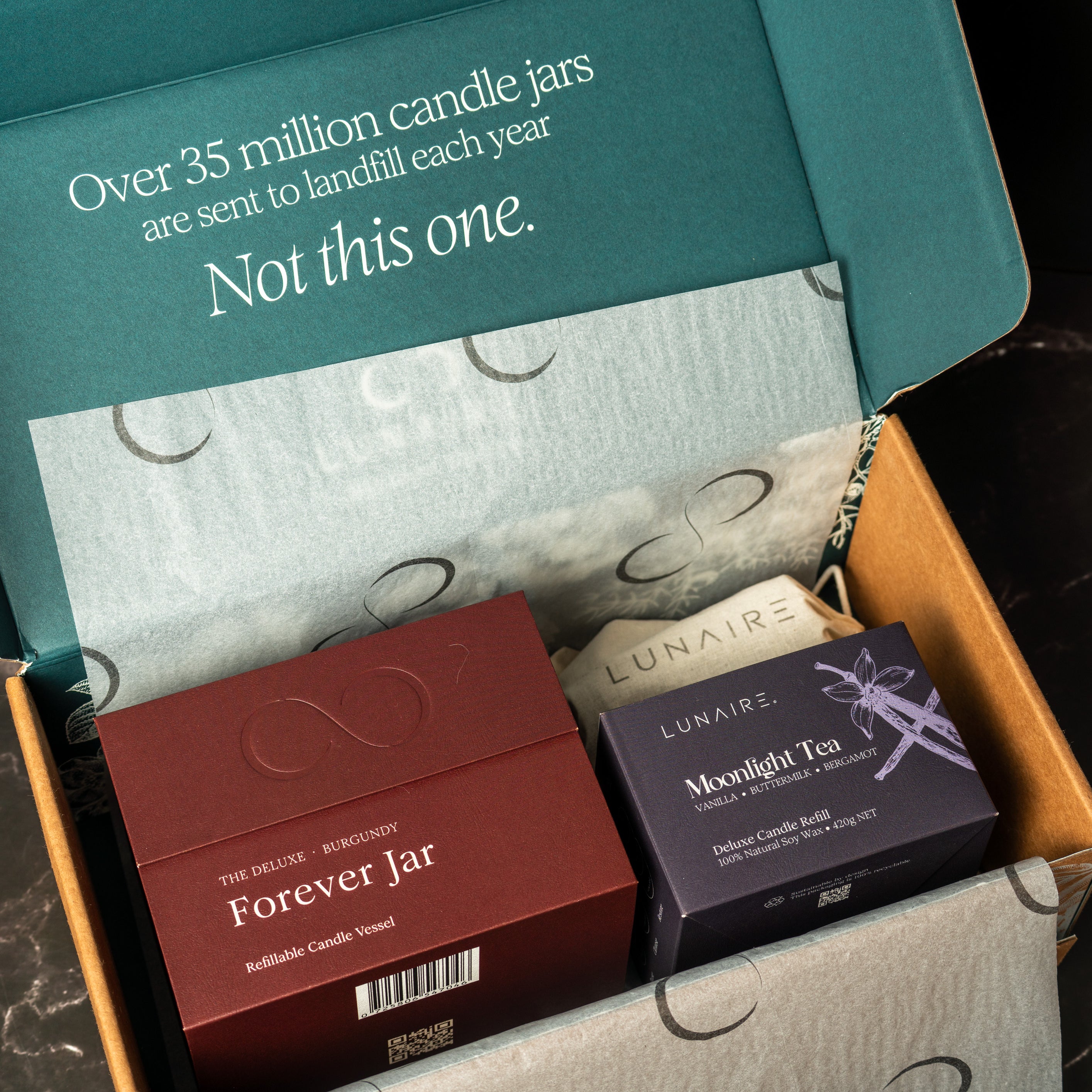 Open box containing candles with a visible message about environmental impact.