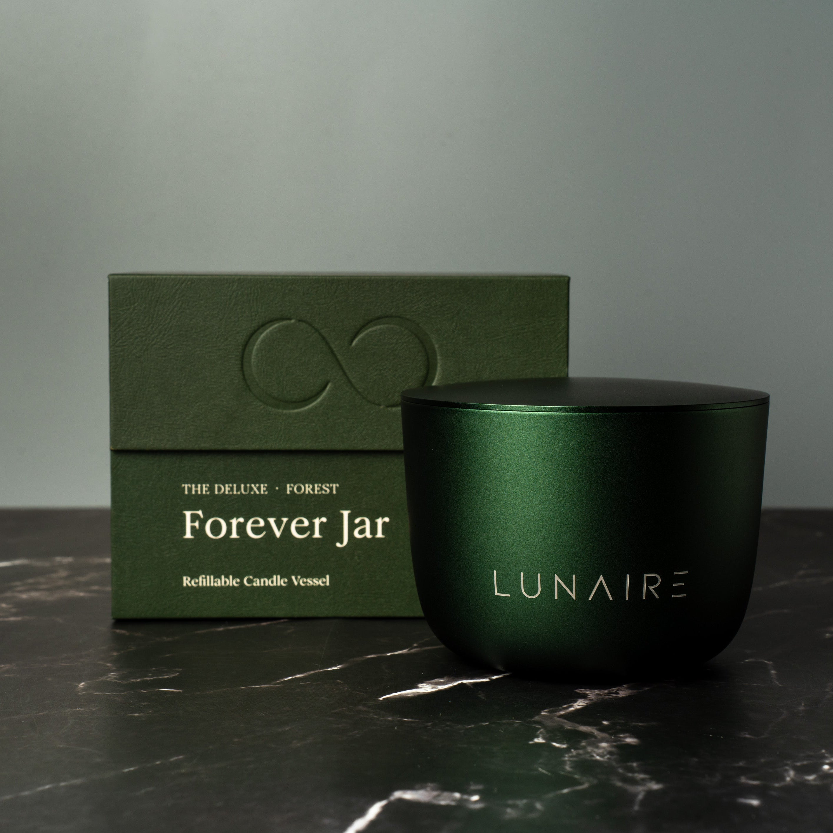 Green candle jar with 'LUNAIRE' branding and packaging on a dark surface. Luxury premium Gift.