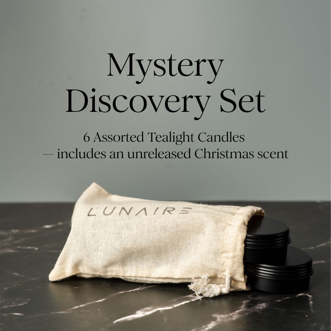 Mystery Discovery Set with 6 assorted tealight candles and a branded pouch on a dark surface.