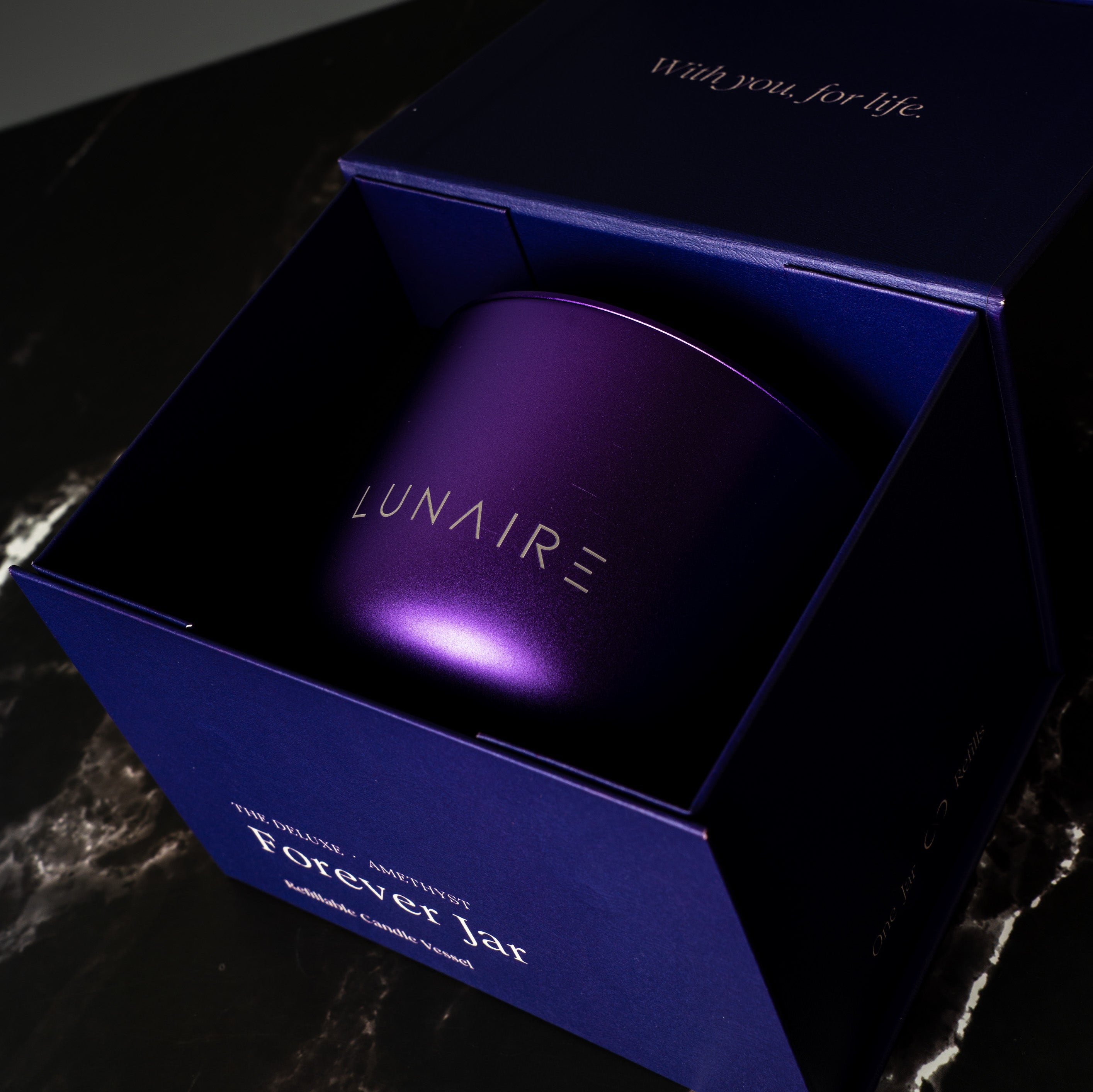 Lunaire Forever Candle in a purple box with branding on a dark background. refillable aluminium Candles.