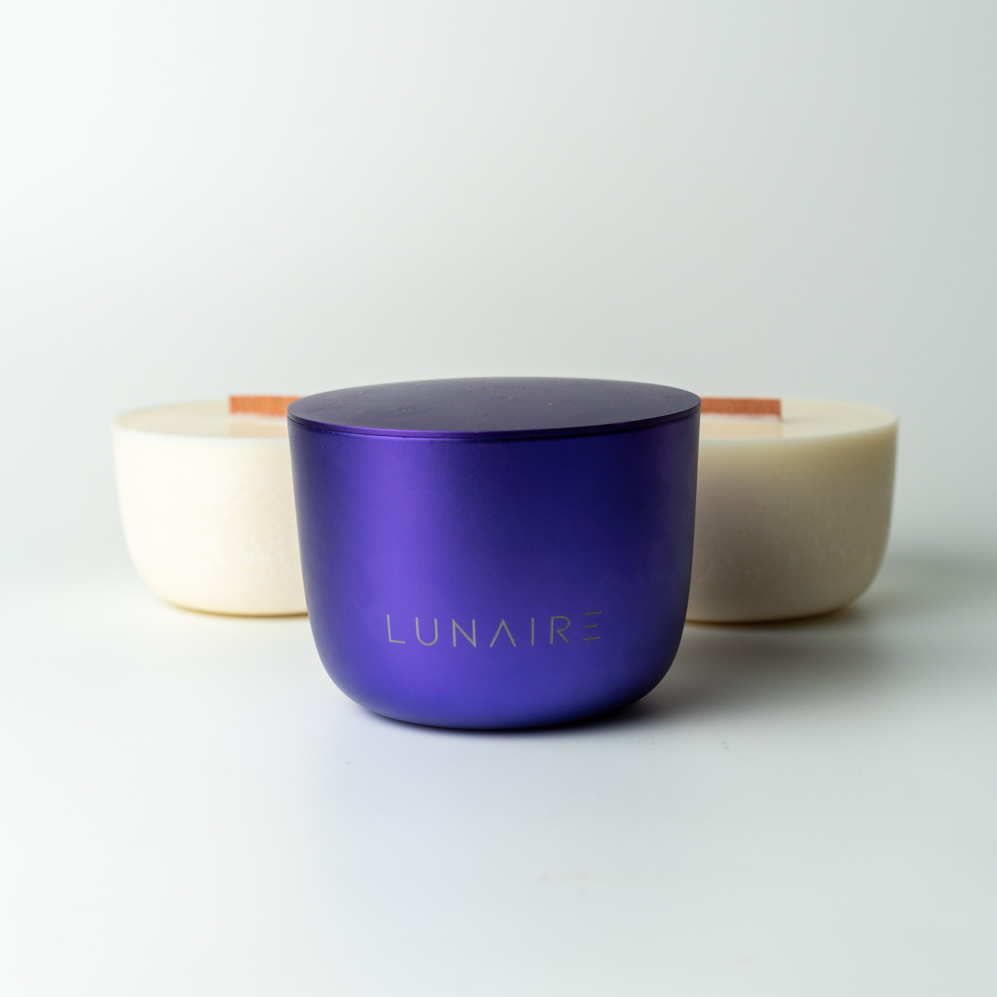 Purple aluminium candle jar and two soy refills with 'LUNAIRE' branding on a white background