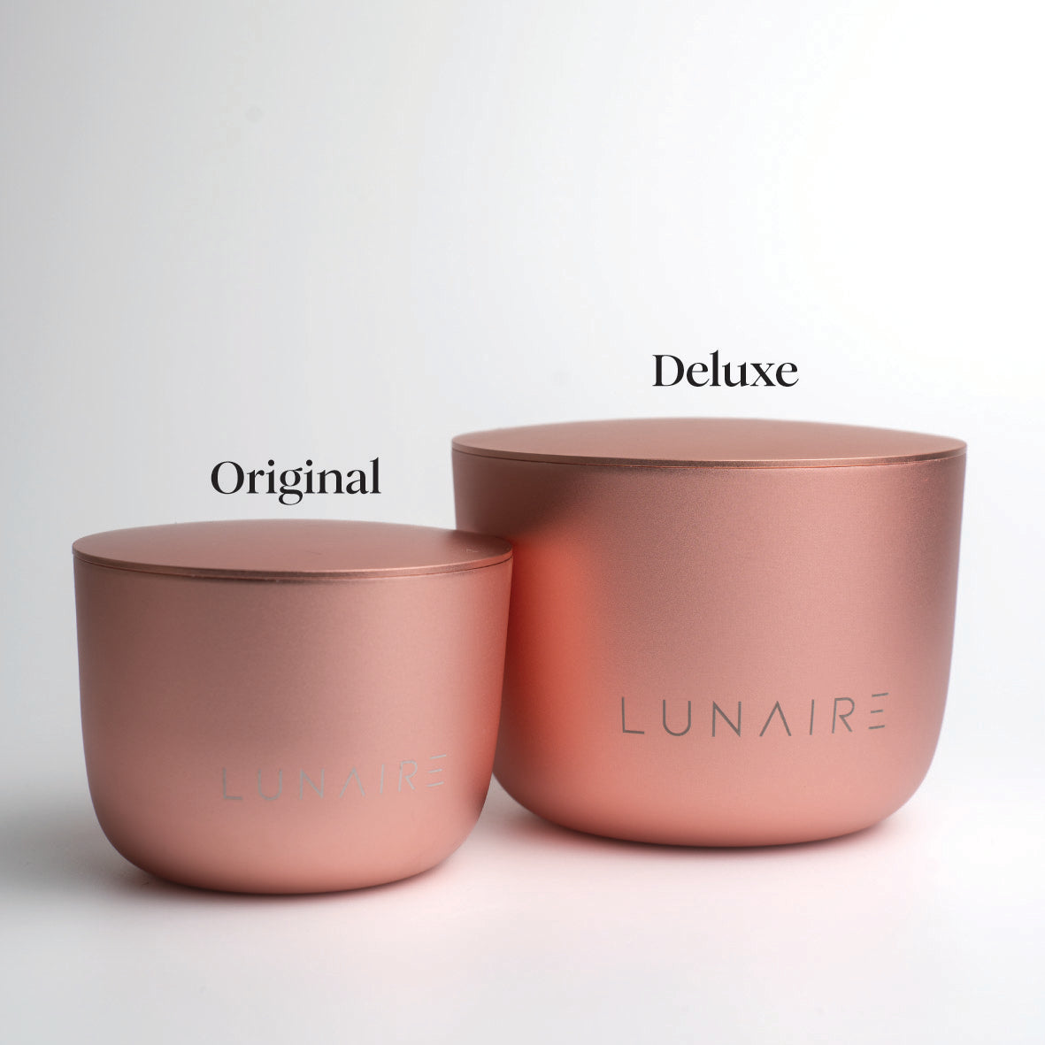 Two rose gold aluminium candles labeled 'Original' and 'Deluxe' by LUNAIRE on a light gray background.