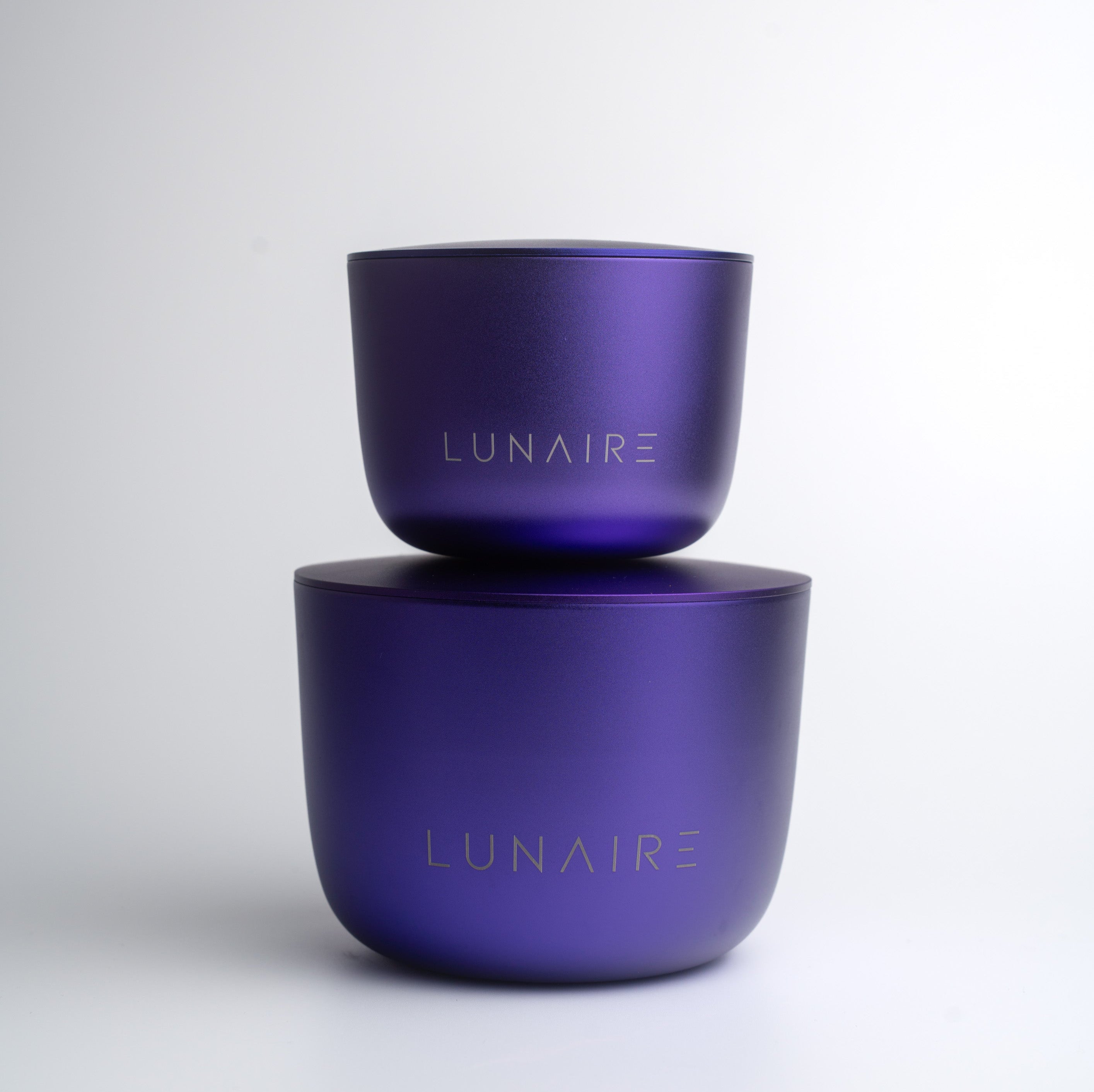 Two purple candle jars stacked on a white background with 'LUNAIRE' branding.