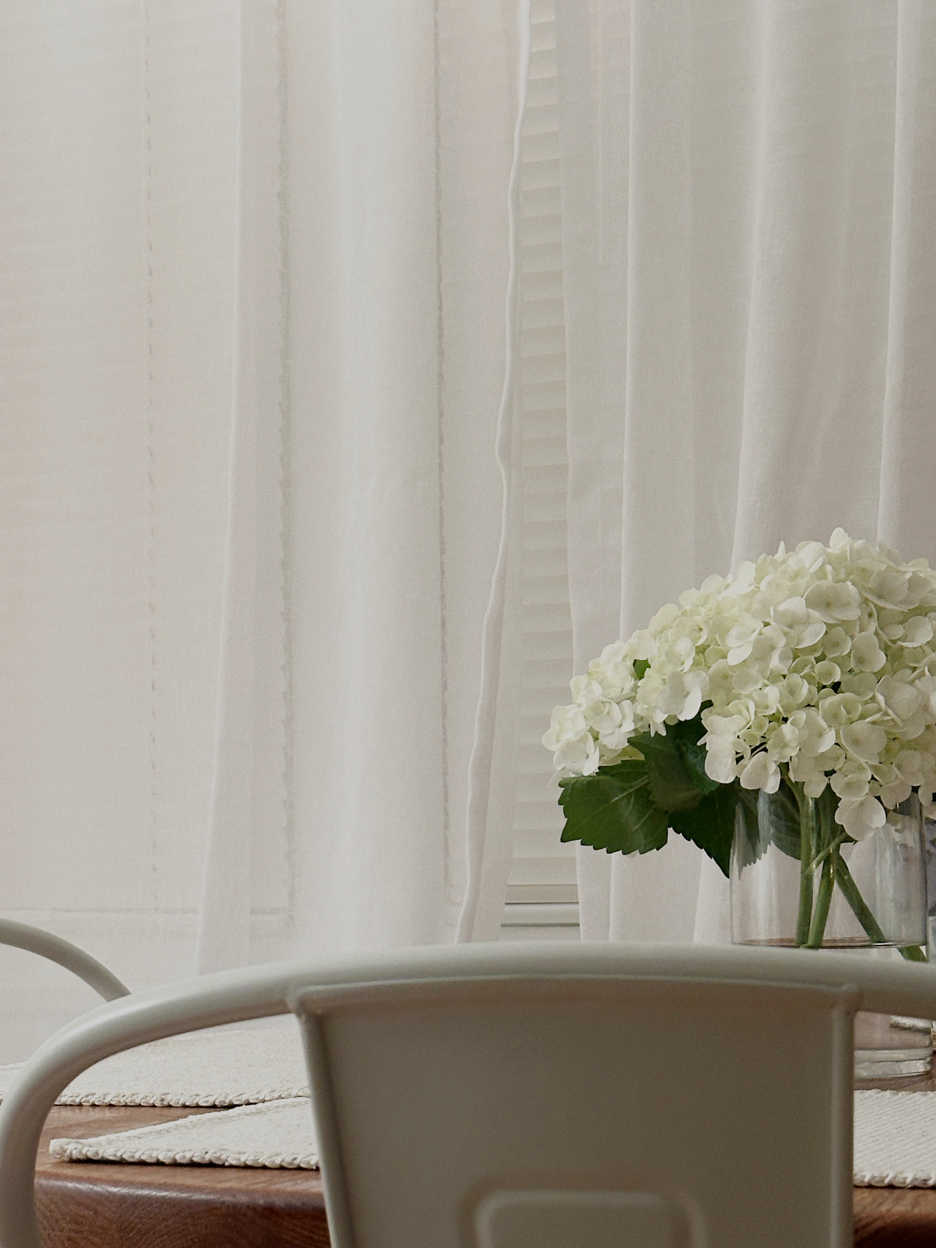 white table and curtains. vanilla scented soy candle