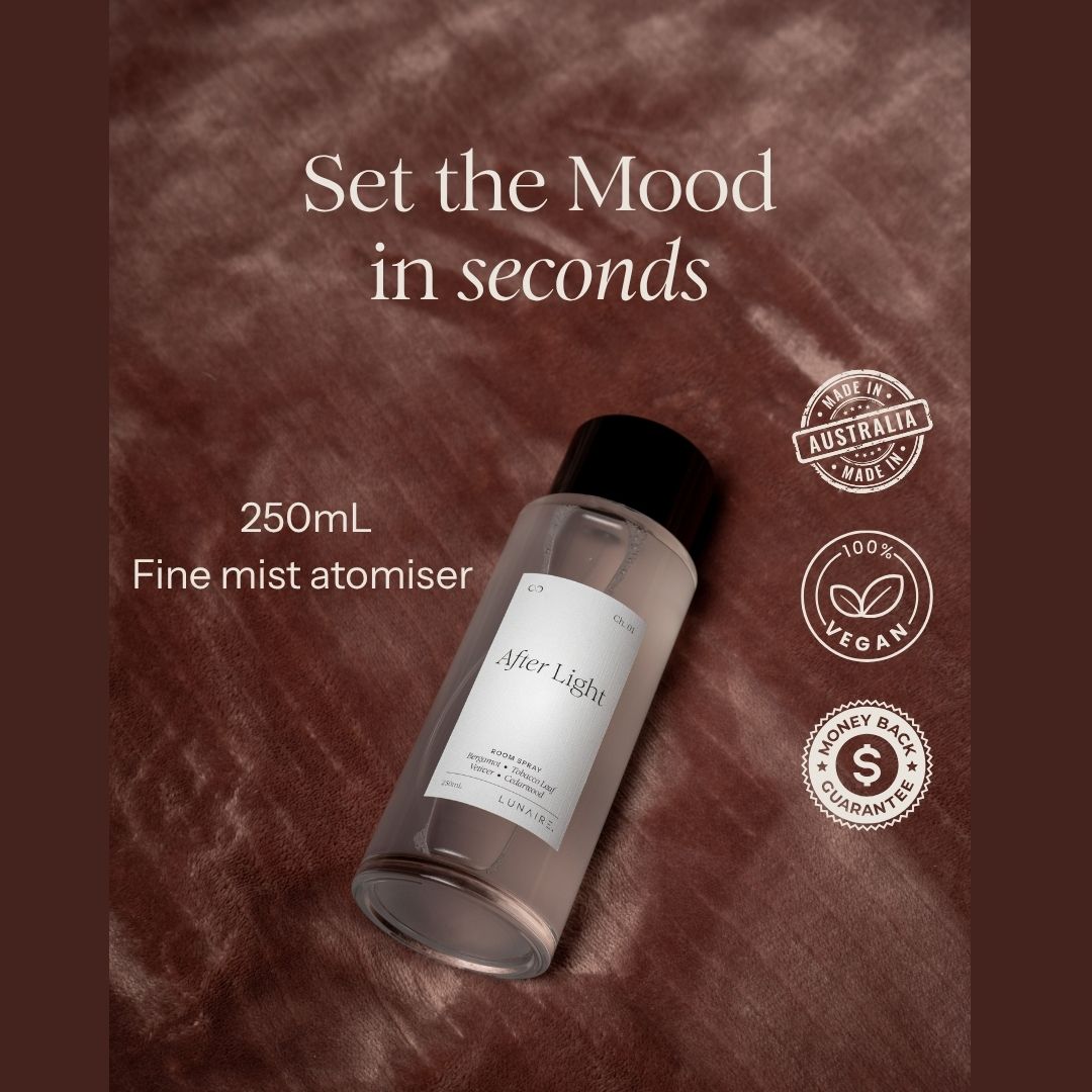 A 250mL fine mist atomiser bottle labeled 'After Light' resting on a textured brown fabric background. The image includes marketing text 'Set the Mood in seconds' and three circular badges reading 'Made in Australia', '100% Vegan', and 'Money back guarantee'
