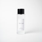 A clear glass bottle of After Light setting spray with a black cap and a minimalist white label, centered against a clean white background.