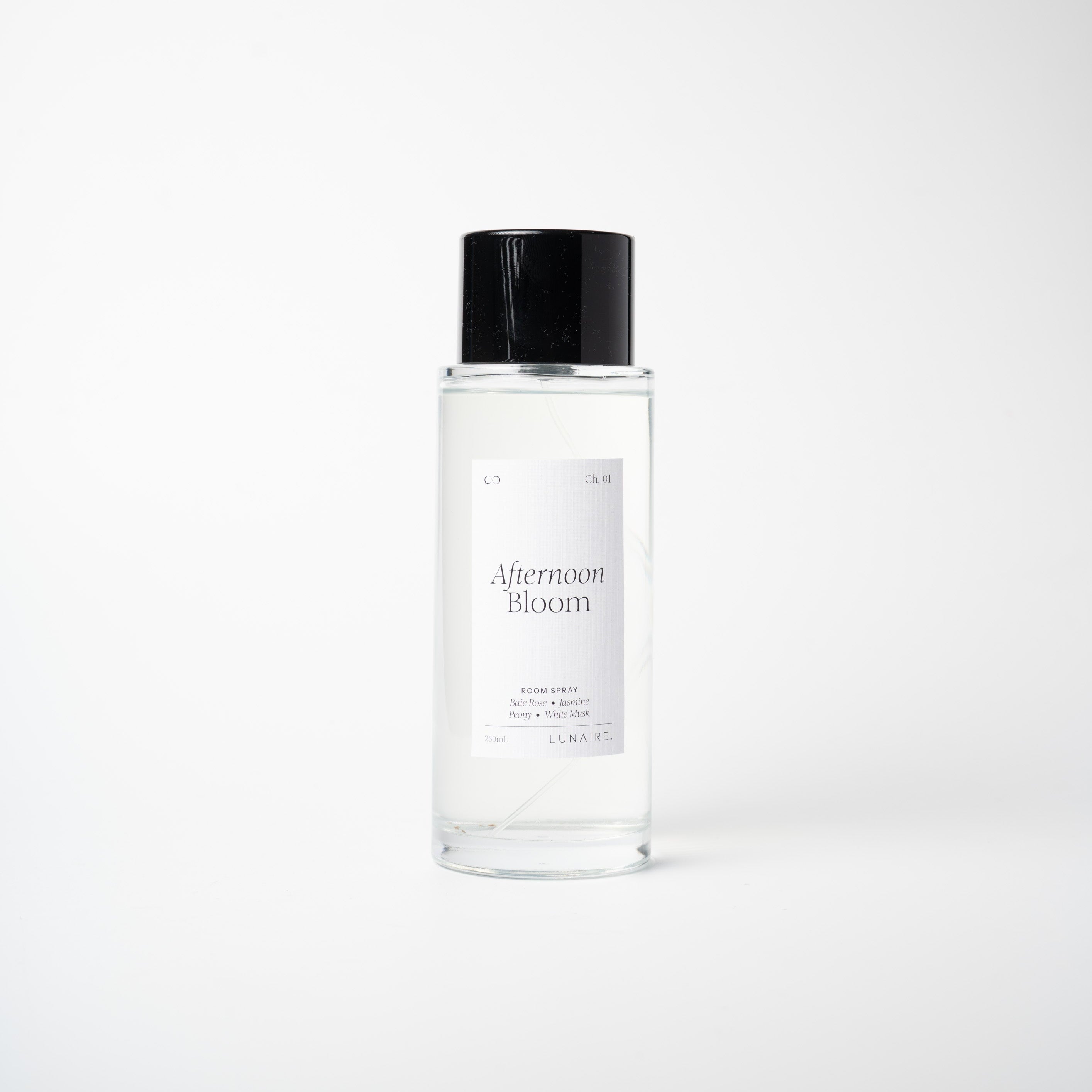 A clear glass bottle of Afternoon Bloom room mist with a black cap, centered against a clean white background.