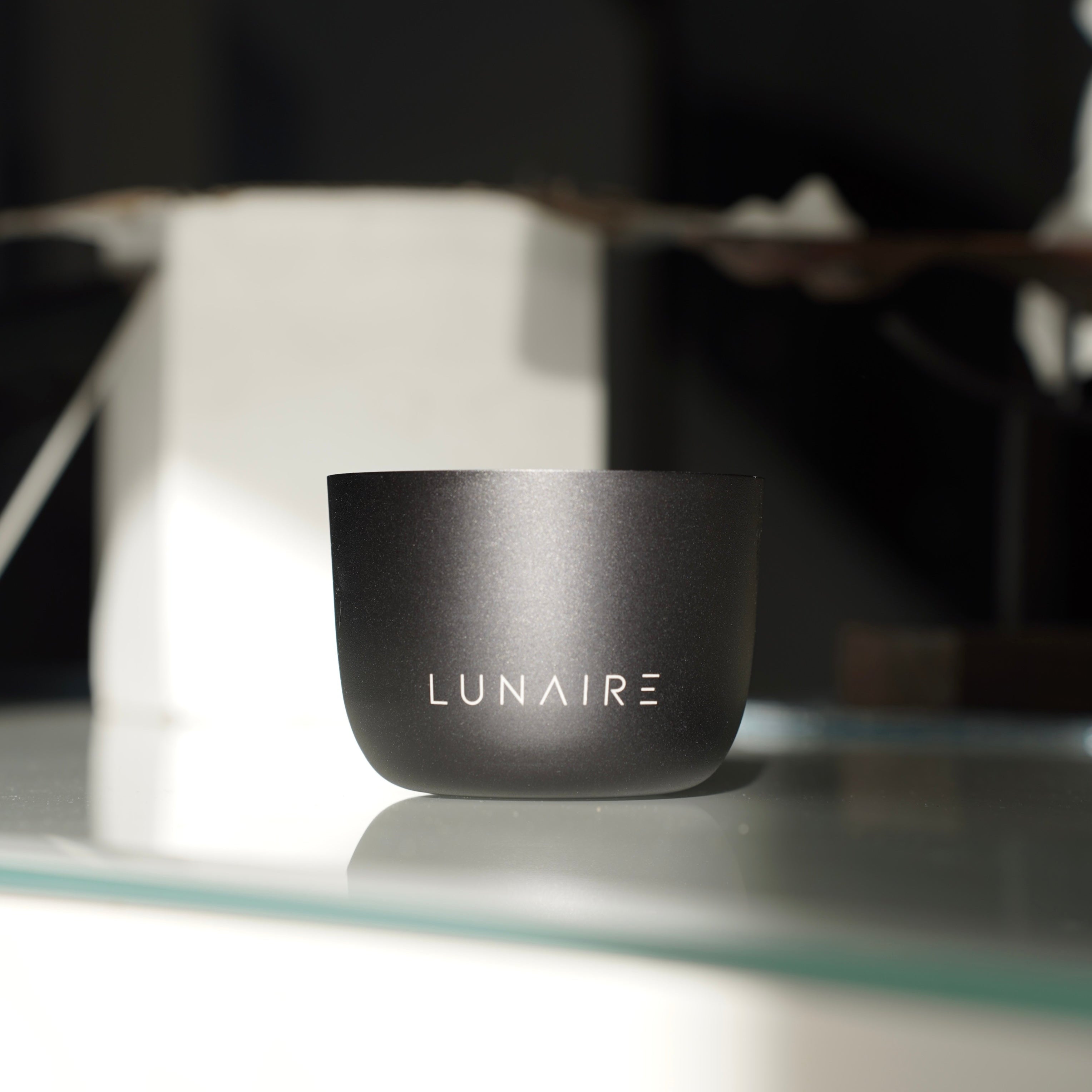 Lunaire Aluminium Black Candle Jar on a glass table 