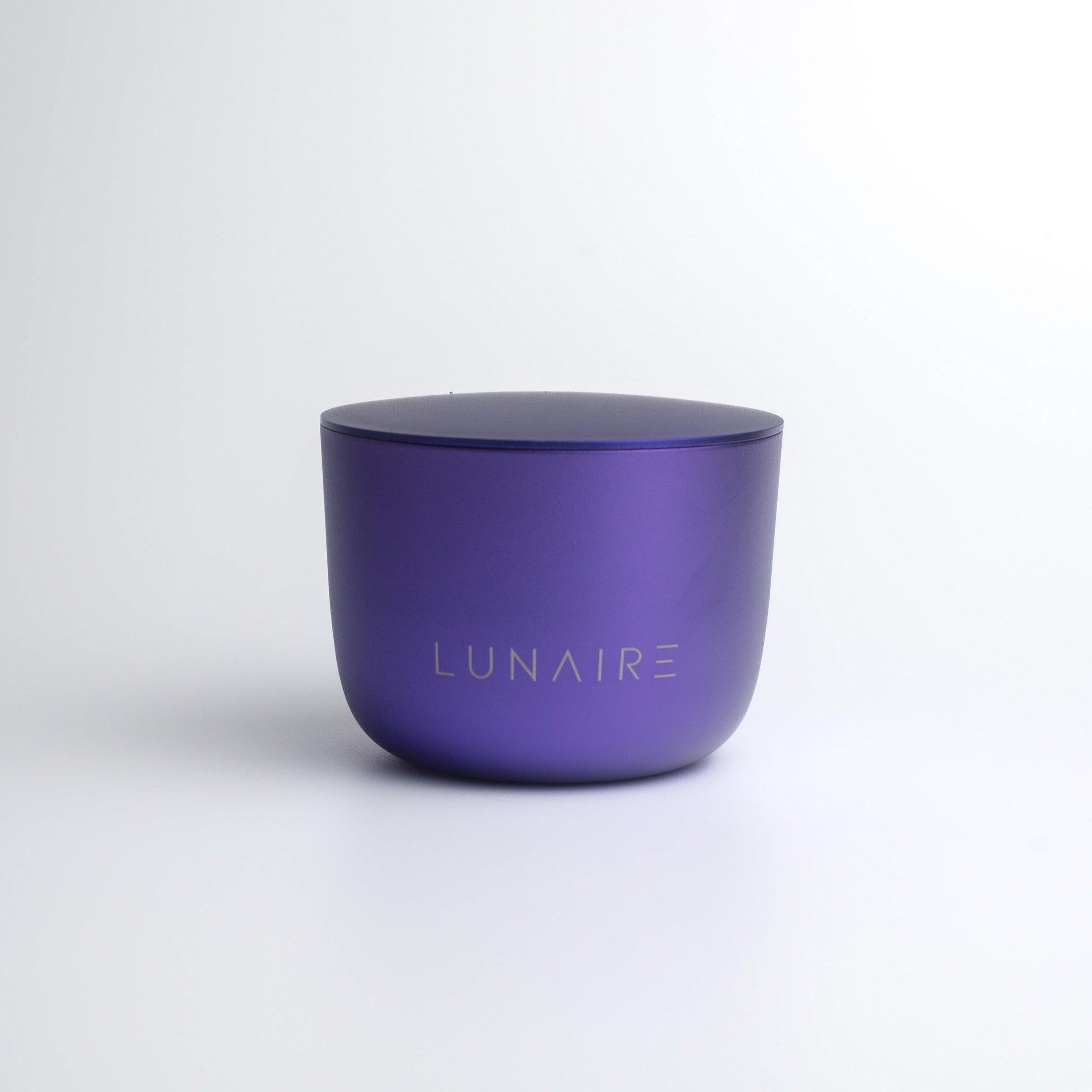 Purple candle with 'LUNAIRE' branding on a white background
