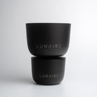 Two black aluminium forever candle jars with 'LUNAIRE' branding on a white background