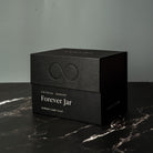 Black premium gift box labeled 'Forever Jar' on a marble surface with a gray background