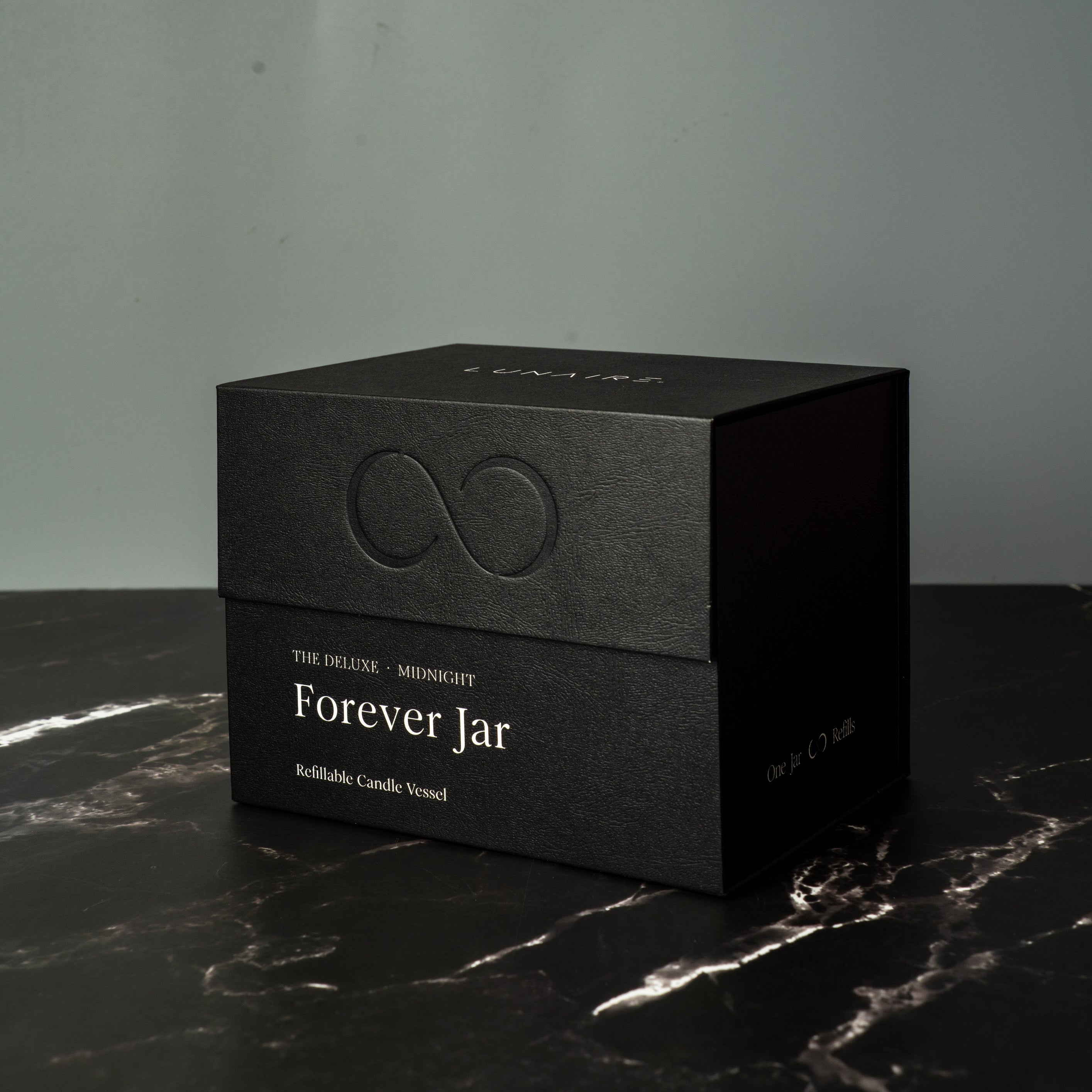 Black premium gift box labeled 'Forever Jar' on a marble surface with a gray background