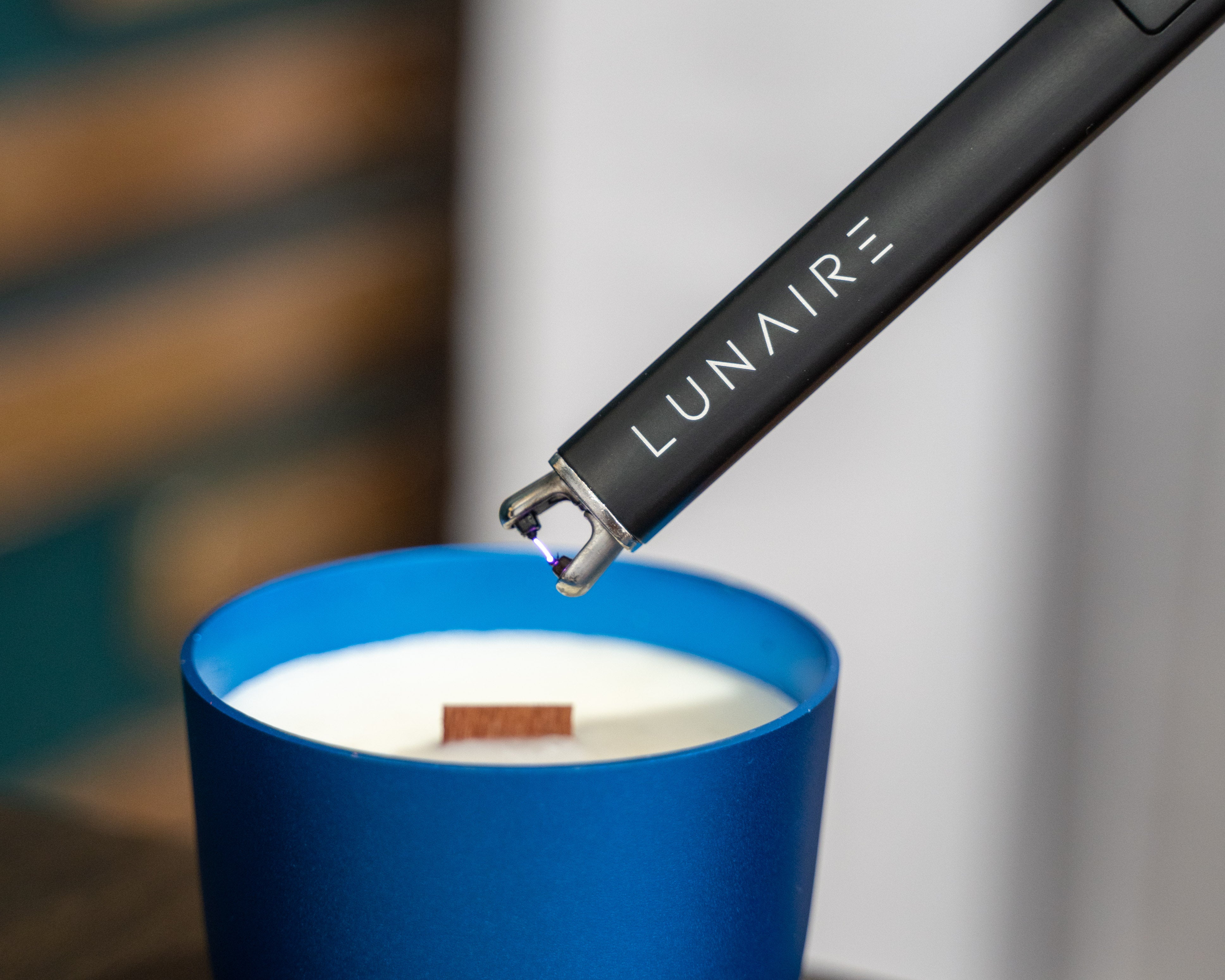 Blue Forever Jar Refillable soy candle with wood wick. Rechargeable arc lighter being used to light the candle. 