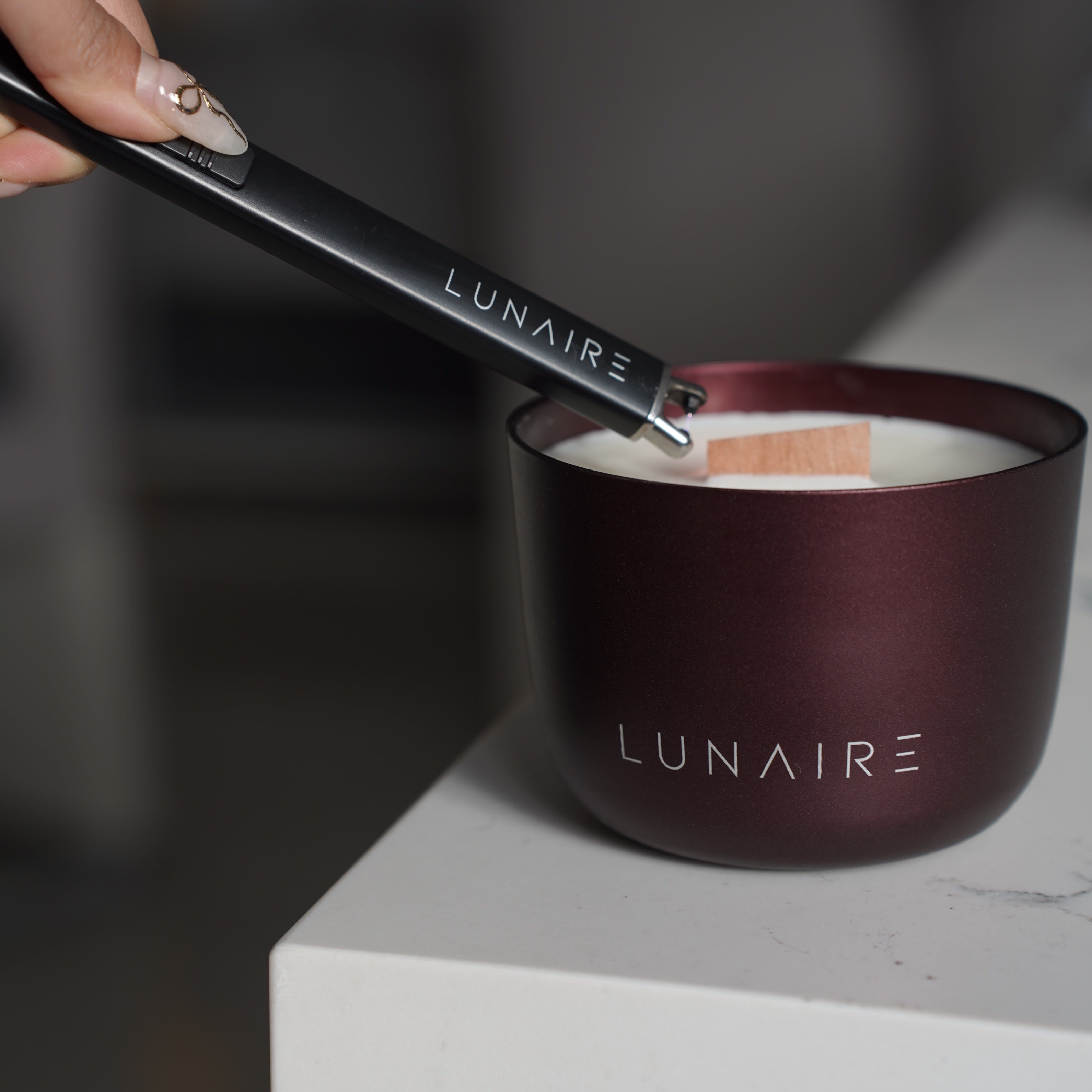 Large burgundy Forever Candle being lit by lunaire lighter 