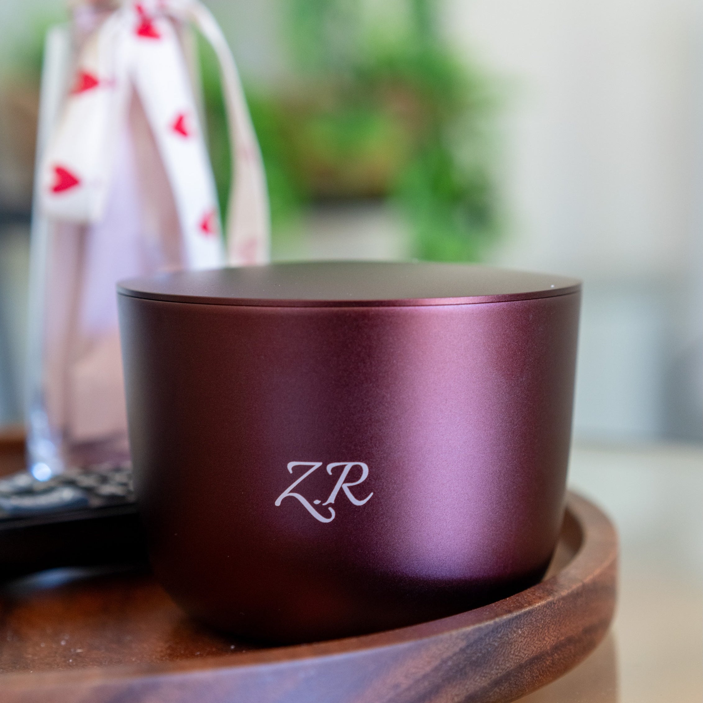 rich burgundy luxury candle on a wooden surface 