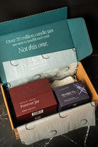Open box containing candles with a visible message about environmental impact.