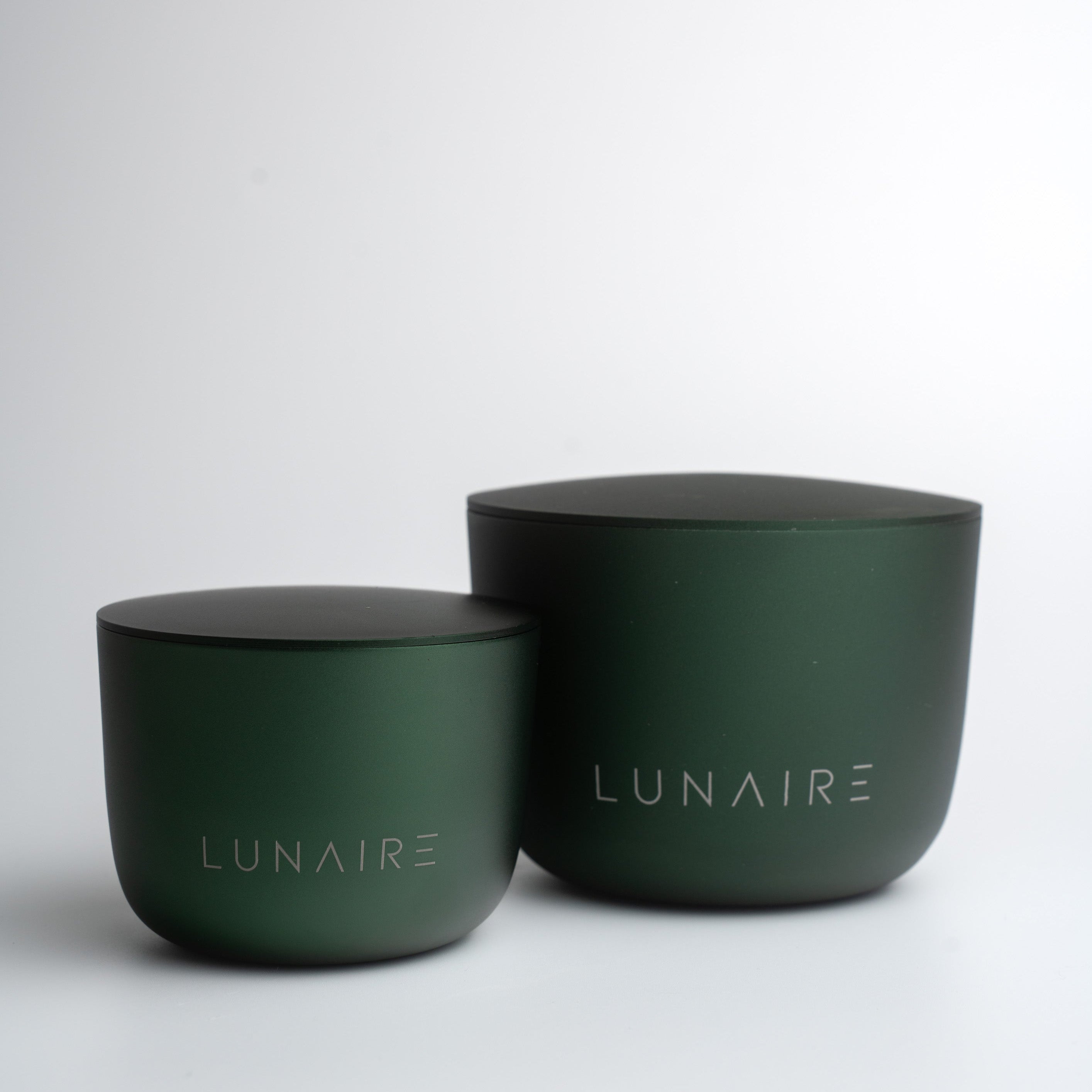 Two green aluminium jars with lids on a white background, branded 'LUNAIRE'.