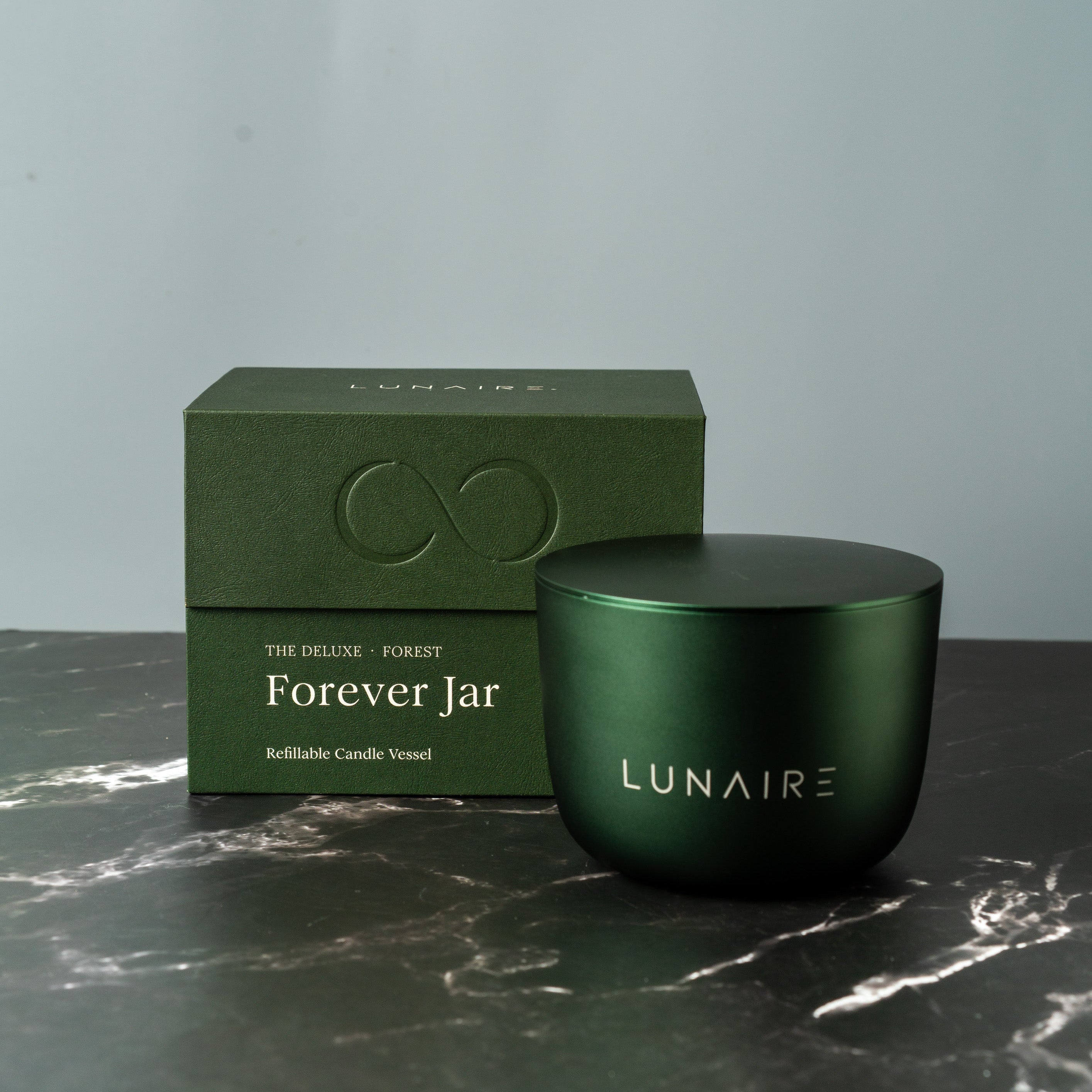 Green refillable candle and premium gift box with 'Lunaire' branding on a marble surface.