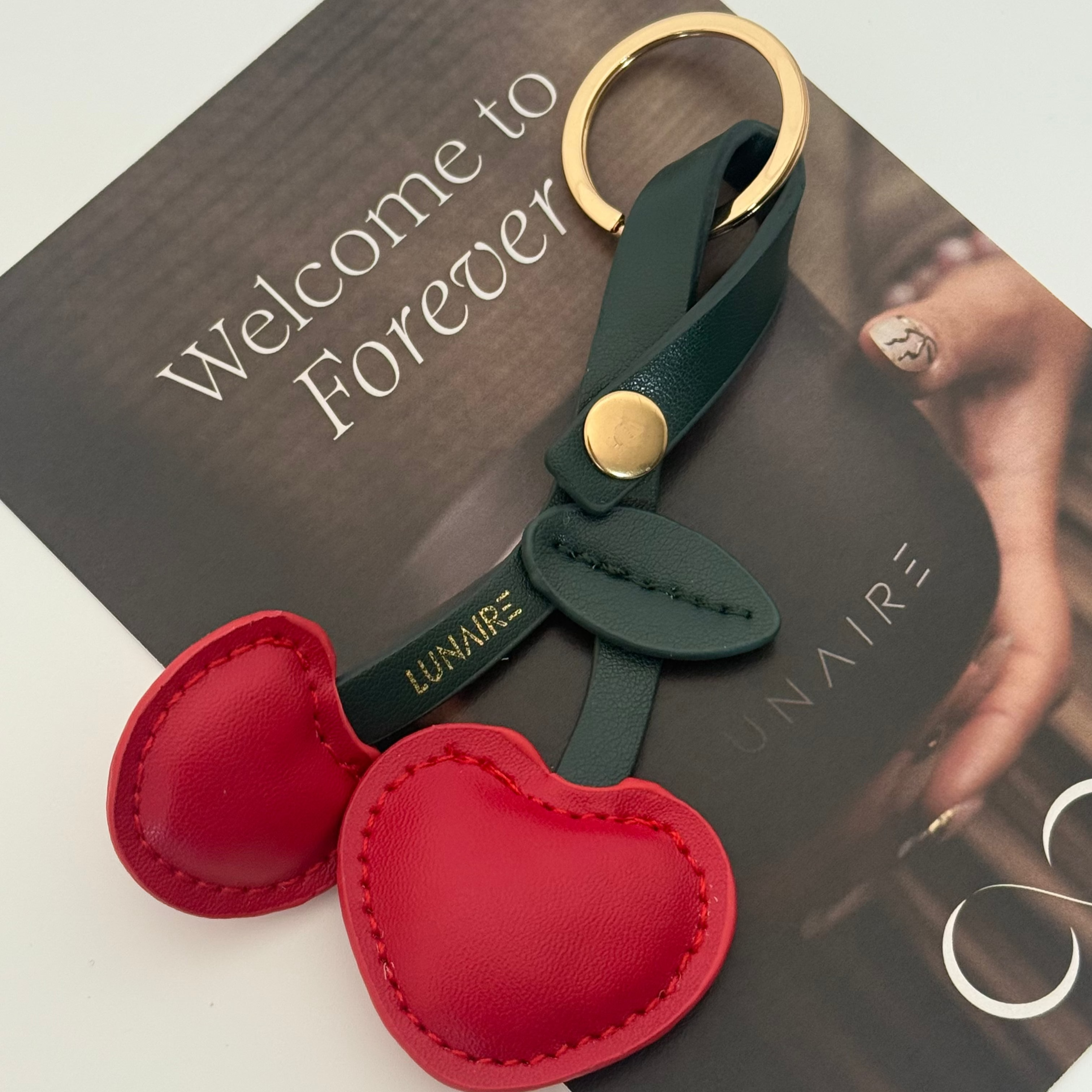 Cherry-shaped keychain with green strap by Lunaire 
