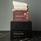 LUNAIRE soy candle and packaging on a dark surface with a gray background. premium gift. 