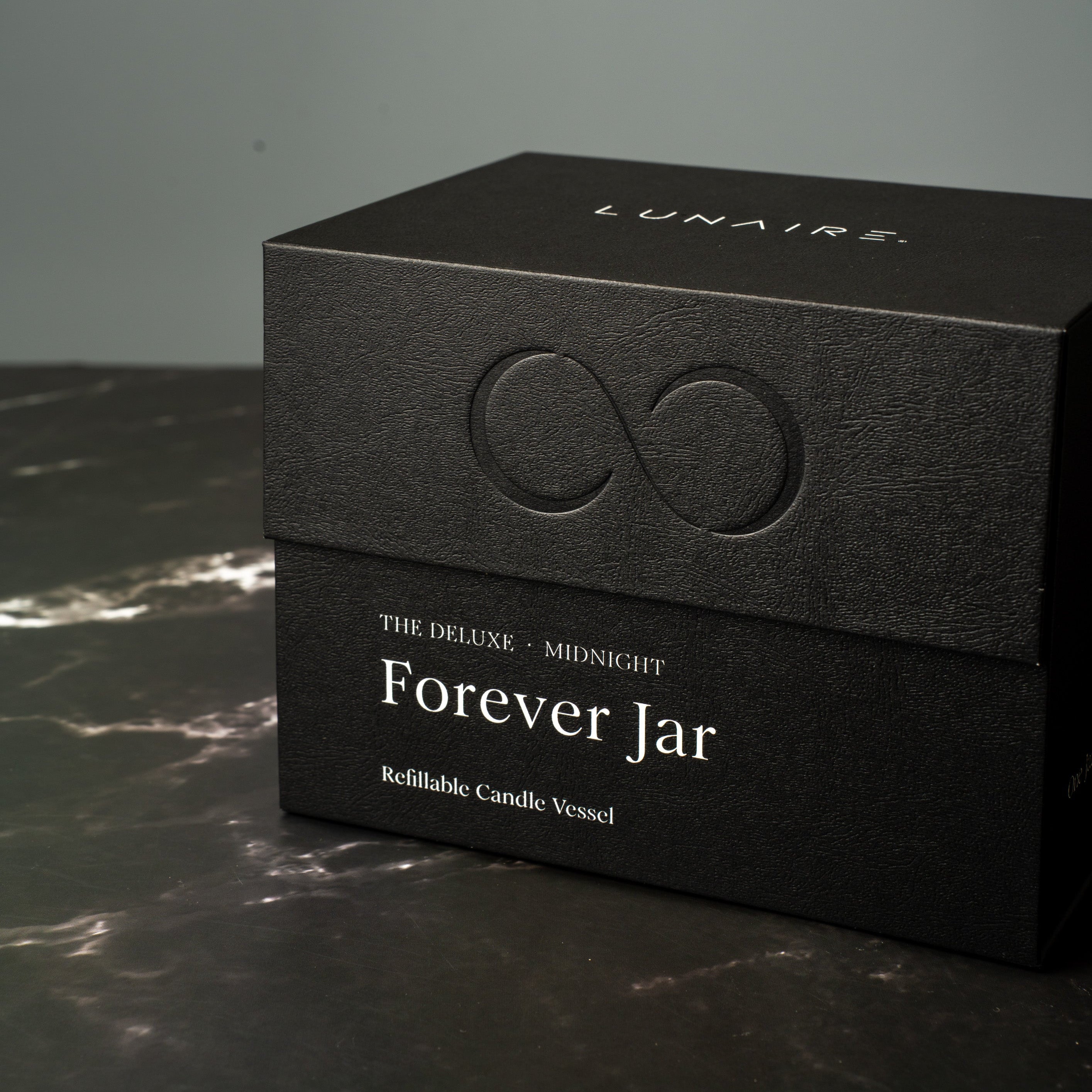 Black gift box with 'Lunaire' branding on a dark surface. Refillable Forever Candle Jar. 