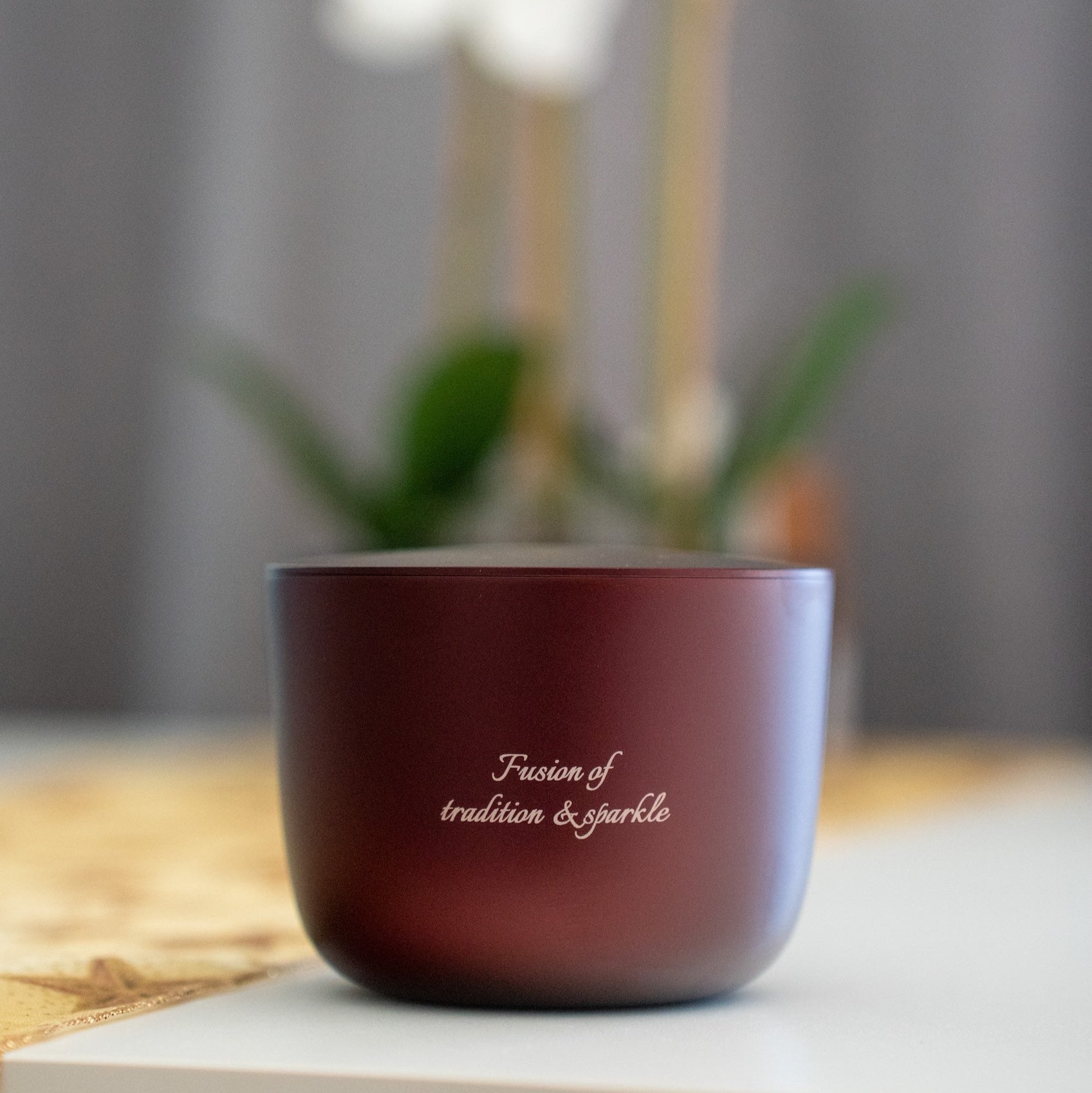 Rich burgundy luxury aluminium candle on a white table
