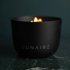 Midnight Black Aluminium candle bu Lunaire lit on a marble benchtop 