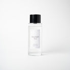 A clear glass bottle of Moonlight Tea room spray mist with a black cap and a minimalist white label, set against a seamless light gray background.