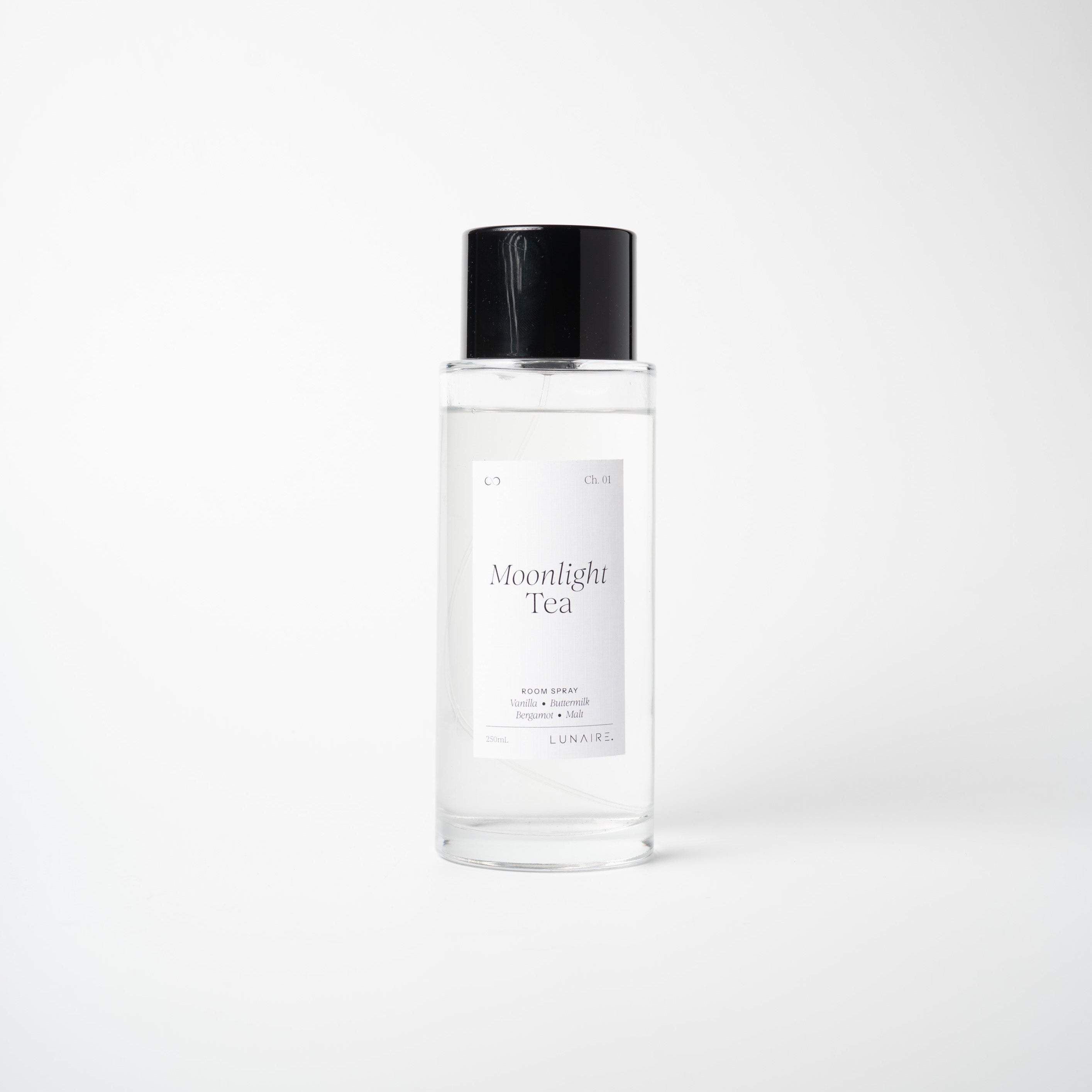 A clear glass bottle of Moonlight Tea room spray mist with a black cap and a minimalist white label, set against a seamless light gray background.