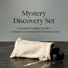 Mystery Discovery Set with 6 assorted tealight candles and a branded pouch on a dark surface.