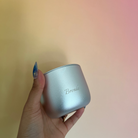 Hand holding a silver Lunaire aluminium Forever Jar with 'Brenda' engraved against a gradient background