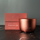 Rose Gold candle jar with 'Forever Jar' packaging on a dark surface. Luxury Premium Candle Gift 