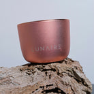 Rose gold container with 'LUNAIRE' branding on a wooden surface