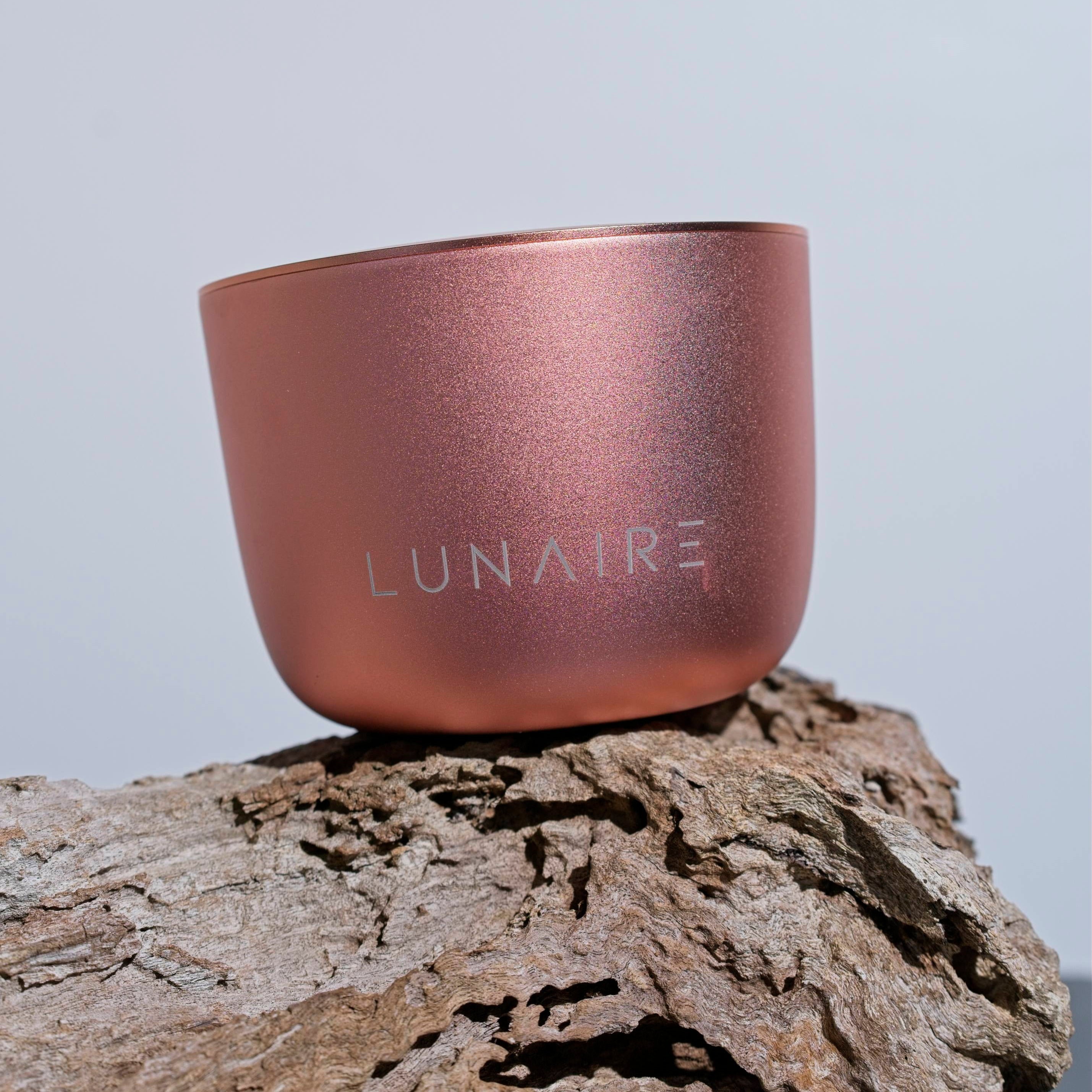 Rose gold container with 'LUNAIRE' branding on a wooden surface