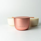 Rose gold aluminium forever candle with 'LUNAIRE' branding on a light gray background with two soy vegan refills