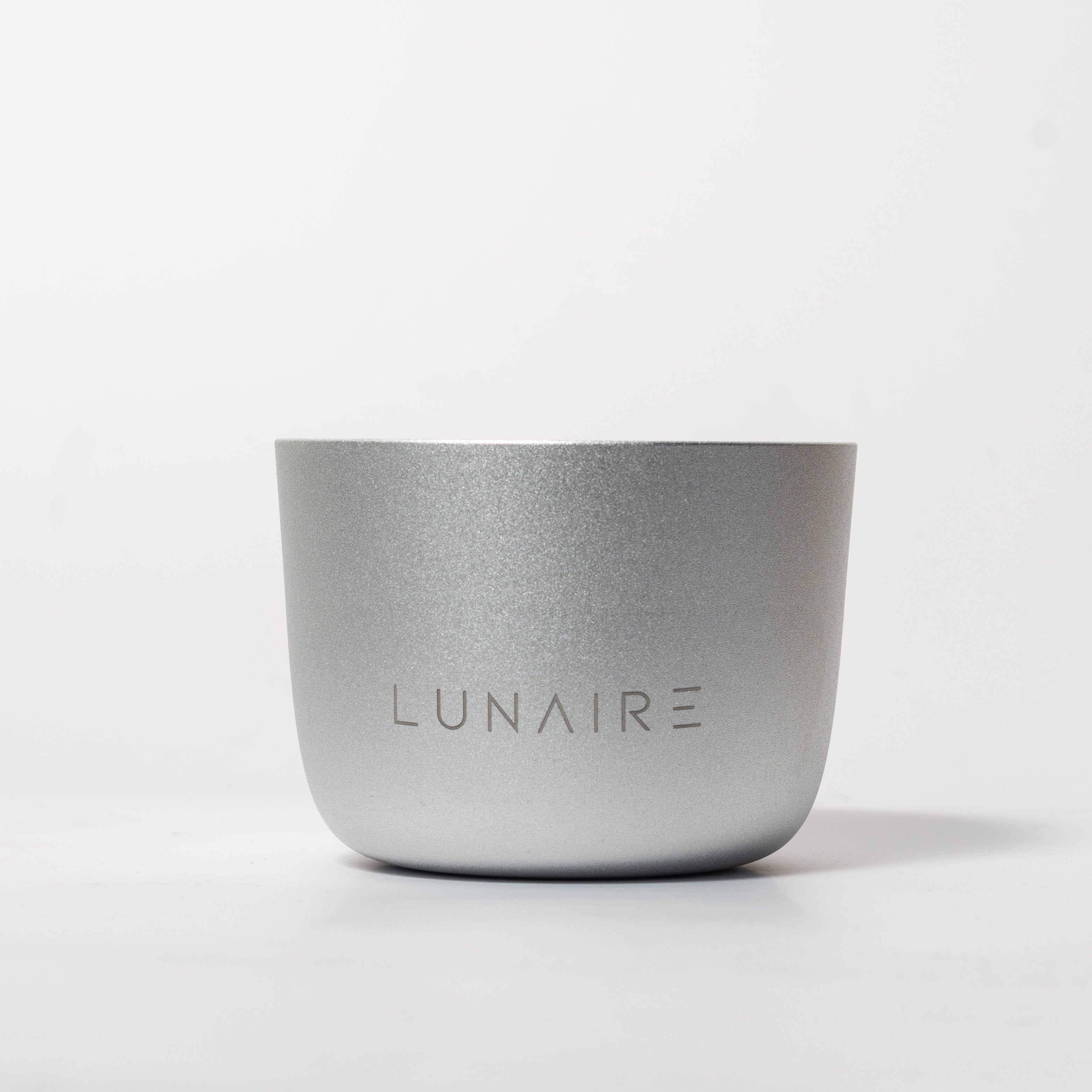 A silver aluminum candle holder with the brand name 'LUNAIRE' engraved on the front.