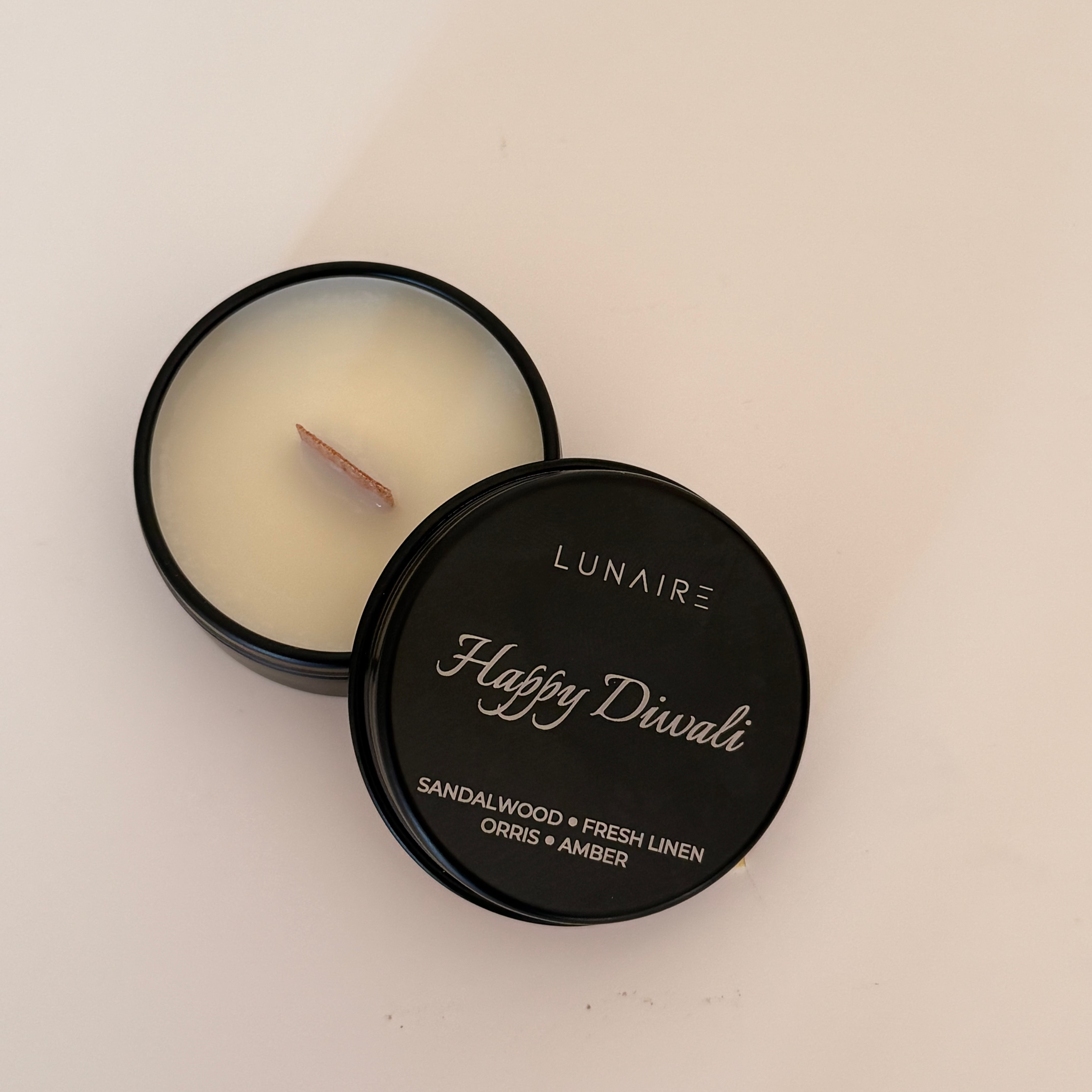 Lunaire Happy Diwali candle in a black container on a light background