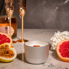 Silver Saturn Lunaire Candle with passionfruit, grapefruit and pink champagne in the back