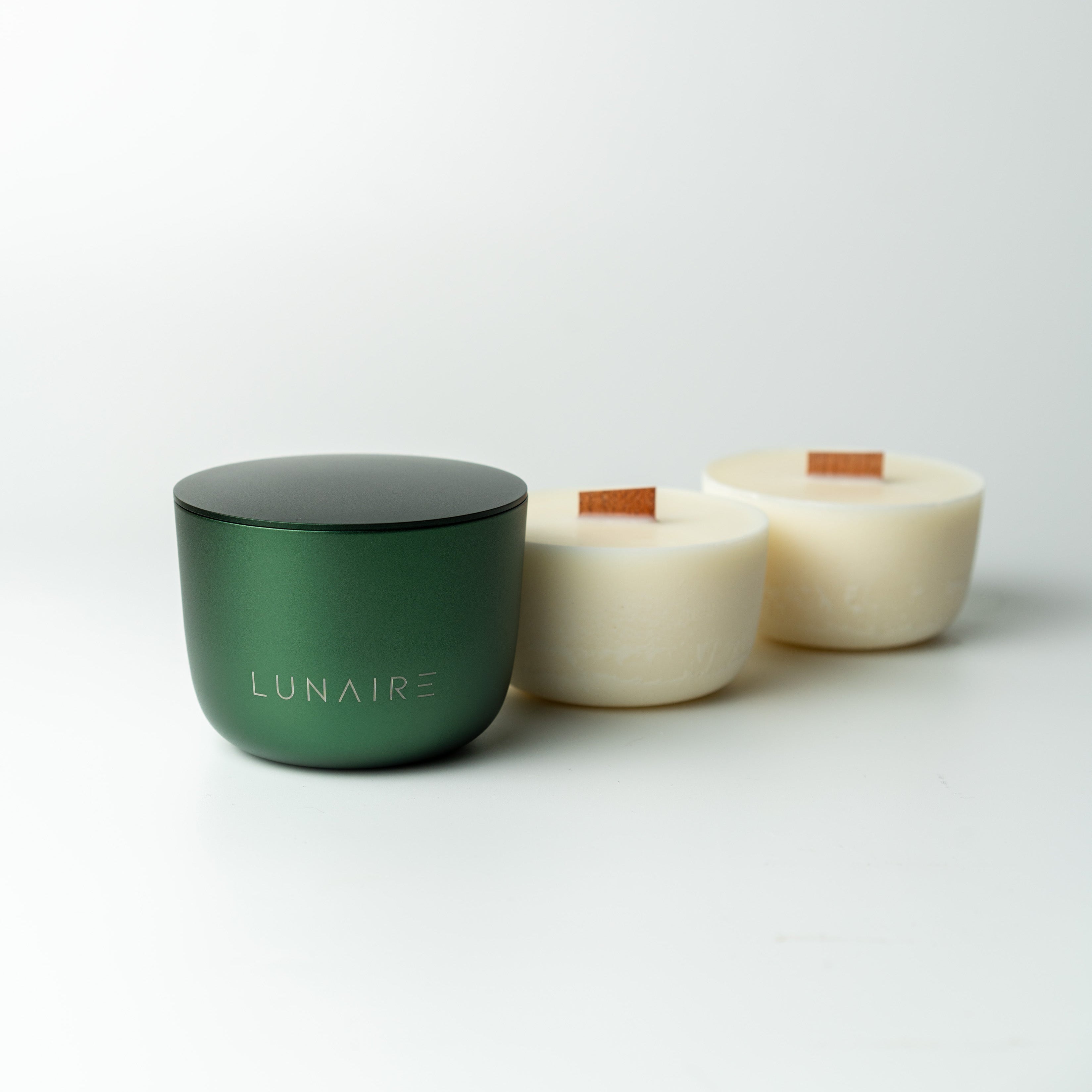 Two candle refills and forest green forever jar on a white background, featuring the brand 'LUNAIRE'.