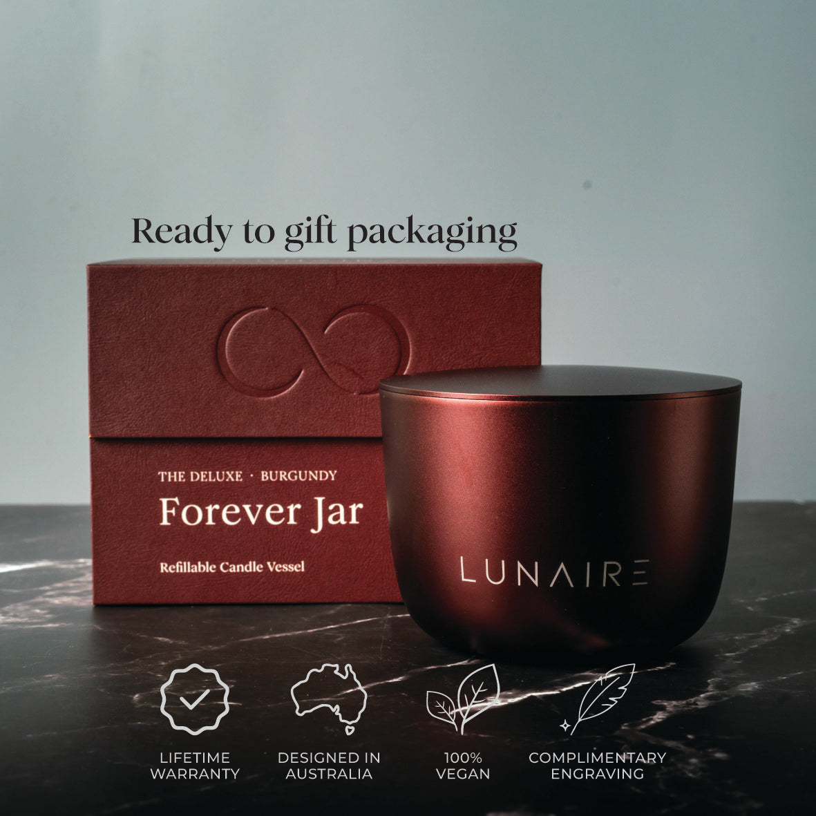Burgundy Aluminium candle vessel and packaging with 'LUNAIRE' branding on a dark surface. Lifetime warranty, designed in australia, 100% vegan , complimentary engraving