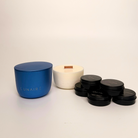 Blue aluminium candle jar, soy candle refill, and black tealight candles  on a beige background with 'LUNAIRE' branding.