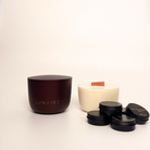 Candle and containers with 'LUNAIRE' branding on a light background