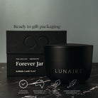 Black candle jar and box with 'LUNAIRE' branding on a dark surface.