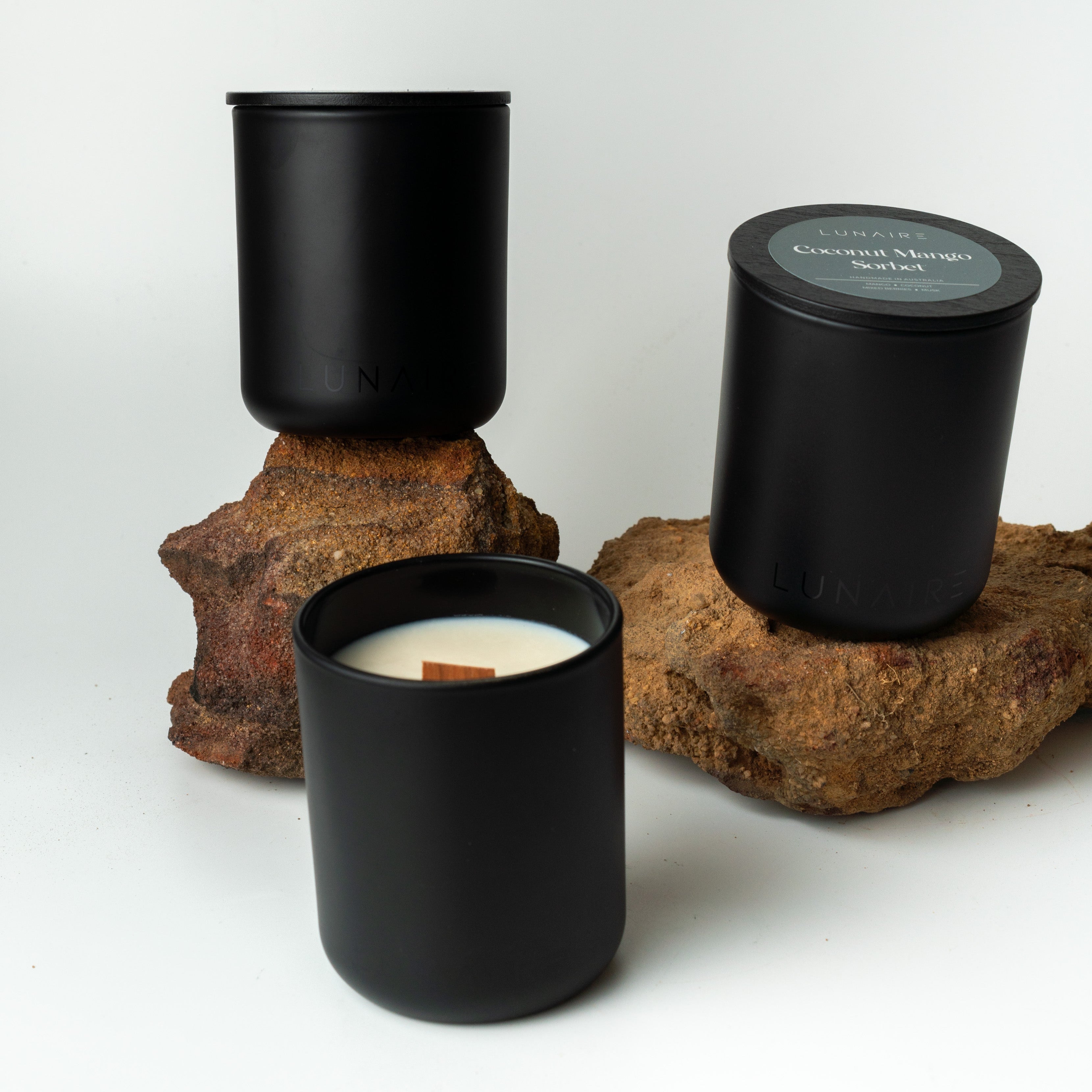 Three black soy glass candles on a white background